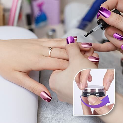 Person applying nail polish with purple metallic nails.